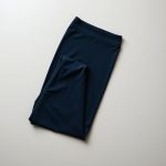 Navy blue scrunch bum flare leggings folded neatly, black wide leg yoga pants on a neutral surface, top-down view.