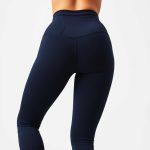 A model wearing flare black yoga pants high waisted gym leggings in navy blue, back view, studio shot on white background.