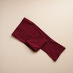 Flat lay of burgundy organic bamboo flare yoga pants, neatly folded on a neutral surface.