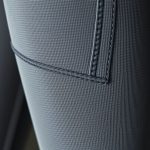Close-up of moisture-wicking performance fabric on leggings with pockets for women, flared leggings petite, showing texture and stitching.