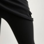 Close-up detail of the black long flare leggings fabric texture and stitching.
