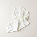 White long flare leggings and wrap top set, neatly folded in a flat lay.