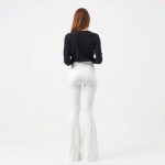 Back view of a model in white long flare leggings and a black wrap top, studio shot.