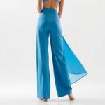 Back view of sky blue yoga flare pants, wide leg workout pants, on a model with white studio background.