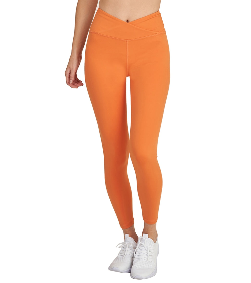 Dusty-orange 7/8 wrap-waist leggings on coastal rocks
