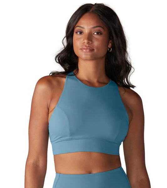 Group of six Australian yogis wearing black workout onesie in tree pose on Bondi lawn, workout onesie